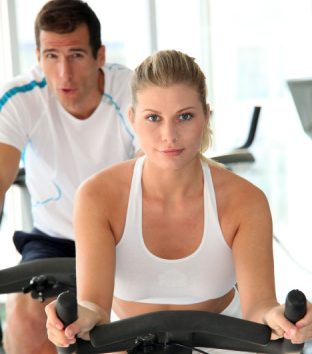 Junge Frau und Junger Mann auf dem Ergometer