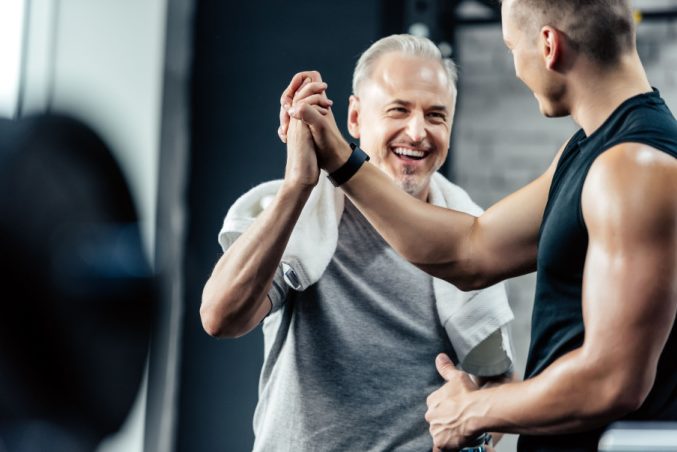 Zwei Männer klatschen ab im Fitness-Studio