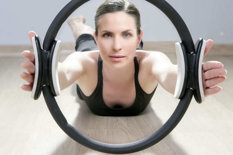 Frau mit Pilatesring im Fitness-Studio